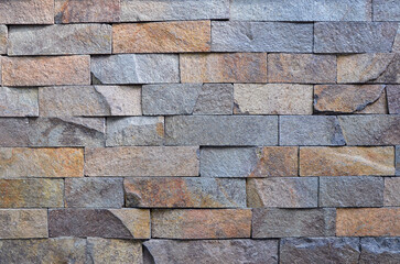  Exterior wall background. Natural stone wall cladding texture in  blue- grey- sand colors. Building industry concept.
