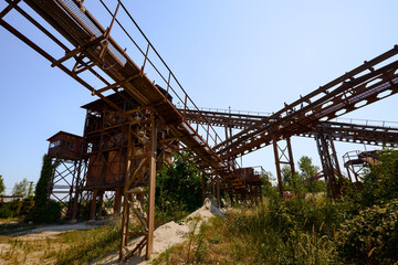 Fototapeta na wymiar Abandoned factory, Gravel mining and production. Belt mechanism. Extruder.