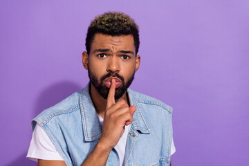 Photo of cute serious guy dressed denim vest asking keep silence empty space isolated purple color background