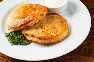 potato pancakes with sour cream on a white plate lunch dinner