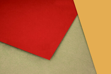 Plain and Textured red mustard yellow brown papers randomly laying to form M like pattern and triangle for creative cover design idea