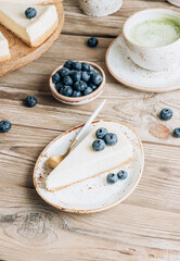 Cheesecake with blueberries on white plate. Classical New York cheesecake. Wooden background