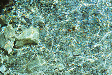 Blurred abstract marine background, stones underwater. Clear sea water covers the rocks.