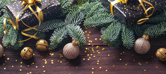 Christmas fir tree branches, Christmas balls, gift box, wooden snowflakes and stars on old brawn wooden background for your xmas greetings. Top view with copy space. Christmas greeting card. Banner.