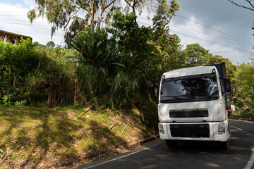 Fototapeta na wymiar Commercial cargo truck on a rural highway in a tropical climate in Colombia.