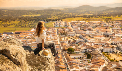 Young woman sitting and looking at Andalusian village panoramic view