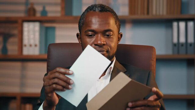 Successful businessman sits in office opening paper envelope reading letter with good news received bank loan approval profitable proposition happy man gets promotion career advance great opportunity