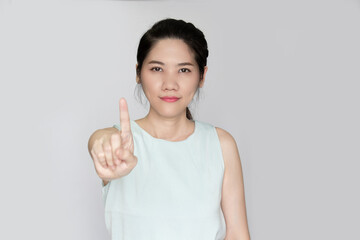 Asian beautiful woman raise indicated finger gesture hand sign to prohibit and warning to people