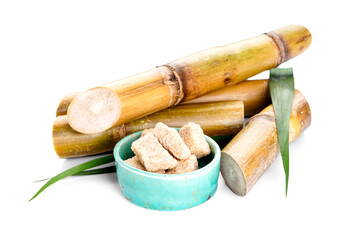 Sugarcane and brown sugar on a white background.
