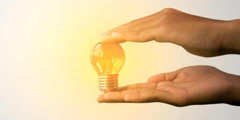 Glowing light bulb in human hand with creative concept of innovation thinking, inspiration success with energy saving