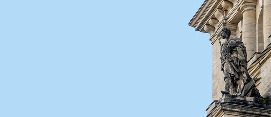 Banner with an old statue of Roman soldier with helmet and spear at the wall of Reichstag building, German Parliament, Berlin, Germany, with copy space and blues sky solid background