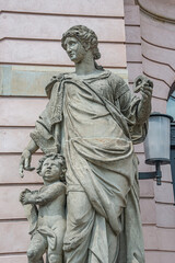 Fototapeta na wymiar Closeup statue view of a Roman scholar woman teaching a child as angel near Berlin Cathedral and Unter den Linden street in historical and museum downtown of Berlin, Germany.