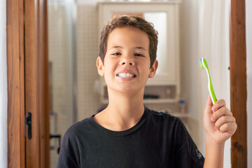 Cute child boy brushing his teeth in the bathroom