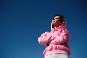 Portrait of fit and sporty young woman doing stretching in city.