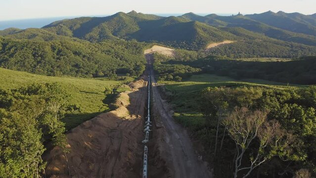 Laying the main gas pipe in a dug trench among the mountains