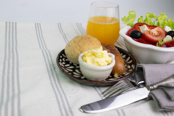 a set of Continental Breakfast , Croissant, bread , sausage and Greek salad