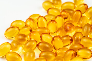 Fish Oil Capsules on a White Surface. Healthy Background and Medicine Concept. Omega 3 Natural Fat in Healthy Lifestyle and Sport Dieting. Yellow Pills with Cod Liver Oil Medicines