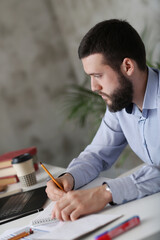 Young stressed handsome businessman working in office. 