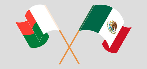 Crossed and waving flags of Madagascar and Mexico