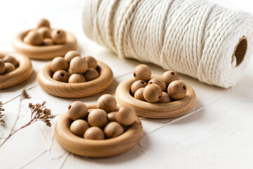 Wooden rings, beads and cotton rope for baby teether on white background. Natural handmade wood toy for child. Eco-friendly children toy. Top view, flat lay.