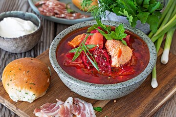 National dish of Ukrainian cuisine borscht with vegetables, turkey meat, herbs, sour cream and traditional bread (bun with garlic and dill, pampushka) with bacon (pork). Cultural heritage.