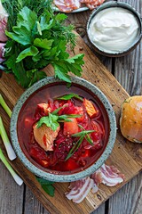 National dish of Ukrainian cuisine borscht with vegetables, turkey meat, herbs, sour cream and traditional bread (bun with garlic and dill, pampushka) with bacon (pork). Cultural heritage.