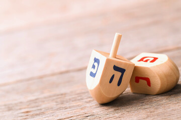 Banner of jewish holiday Hanukkah with wooden dreidels (spinning top) over glitter shiny background