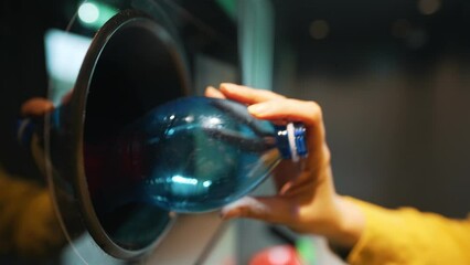 Woman puts bottle in automatic bottle recycling machine. Reverse vending recycling machine. - Powered by Adobe