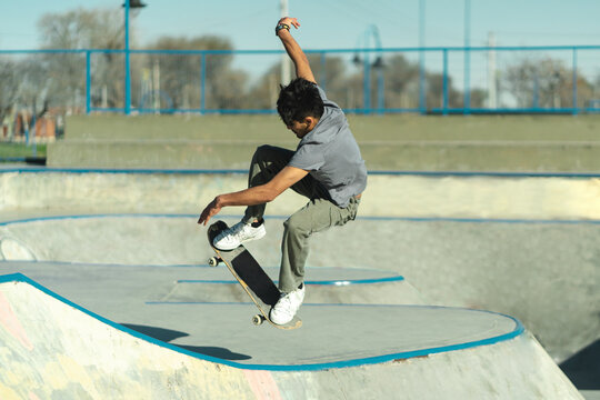 Latin American Skateboarder Doing Trick On Skatepark