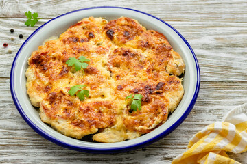 Healthy vegetable chicken cheesy bake on wooden background. Top view, copy space, flat lay.