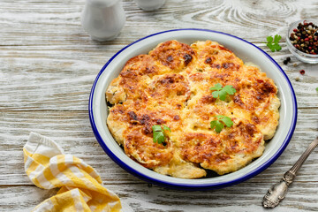 Healthy vegetable chicken cheesy bake on wooden background. Top view, copy space, flat lay.