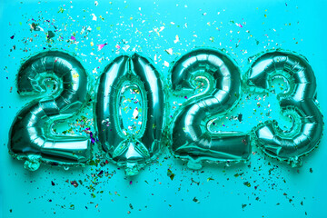 2023 Happy New Year concept from silver foil balloon on blue light