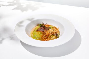 Roasted fish with crispy skin, celery cream and fresh herbs espuma. Fried halibut fillet on mashed celery and crunchy potatoes. Roasted fish fillet in elegant restaurant menu