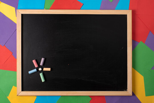 Pizarra en blanco con tizas de colores, fondo con post its de colores, empieza el colegio, educaci&oacute;n y actividades