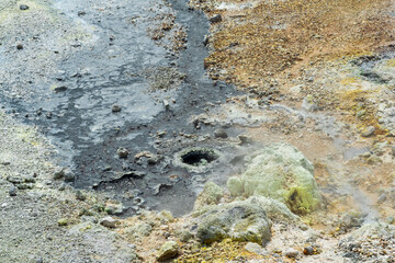 boiling fumaroles and sulfur deposits at the hydrothermal outlet on the shore of the hot lake in the caldera of the Golovnin volcano on the island of Kunashir