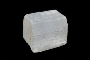 A piece of faceted selenite crystal in the form of a small cube with rough edges