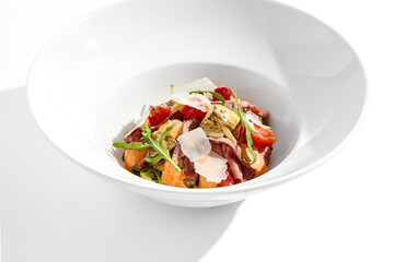 Roast beef and grilled vegetables salad isolated on white background. Steak salad with pastrami, eggplant, tomato, remoulade sauce with parmesan flakes. Gourmet dish  with grilled meat and vegetables.