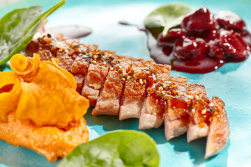 Roast duck breast with batata chips and cherry sauce isolated on white background. Delicious dinner...
