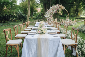 ideas for Wedding Decoration outdoors with white pink and orange flowers in the day light. Table Setting outdoors with flowers arrangement. Refreshing nature environment 