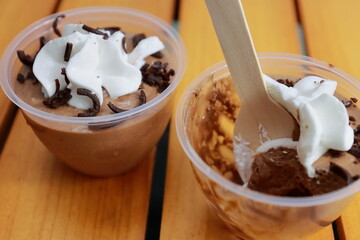 Elegant and delightful tasting chocolate mousse cups in wooden background