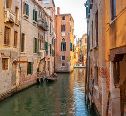 Obraz na płótnie Canvas View on the narrow cozy streets of the canals with parked boats in Venice, Italy. Architecture and landmark of Venice.