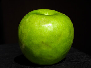 Manzana verde sobre un fondo oscuro