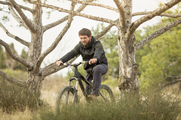 a young man rides a mountain bike in the forest.