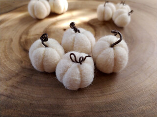 Handmade pumpkins white felt on a wood background. Wool pumpkins. Concept: Halloween decor. Selective focus.