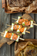 Salmon skewer on wooden boards, over wooden vintage background.