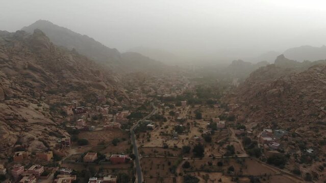 Drone Shot Over Tafraout Village Aday mosque in Morocco Over mountain fog . 