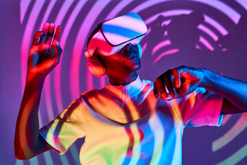 Black man looking at imaginary object while exploring cyberspace in VR glasses