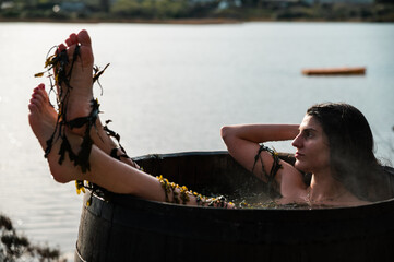 Female taking seaweed bath near lake