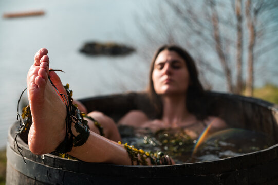 Female taking seaweed bath near lake