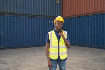 Happy African worker smailing, standing in the container workplace and crossed arms with feeling happiness